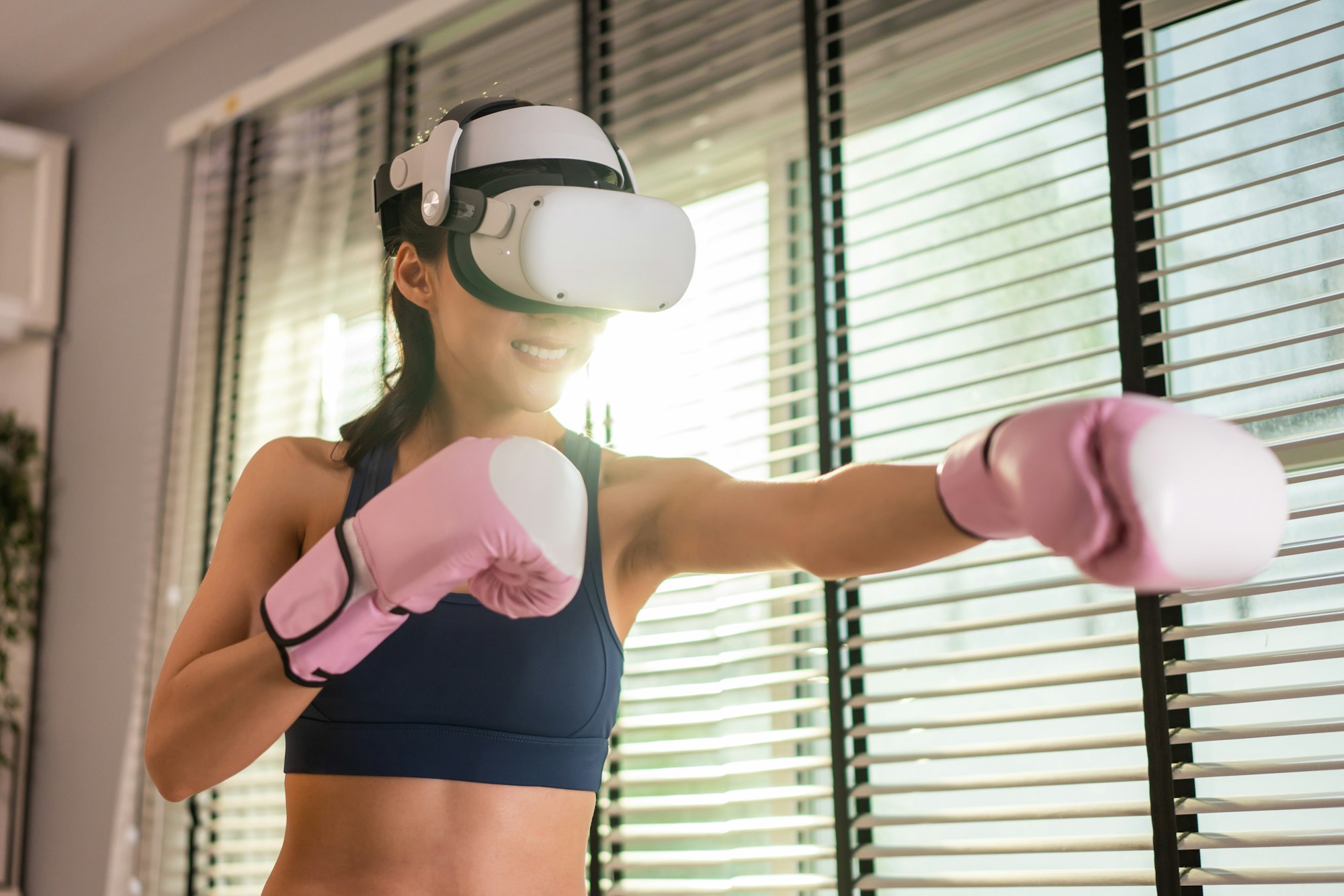 Asian sportswoman using innovative technology VR glasses for exercise.